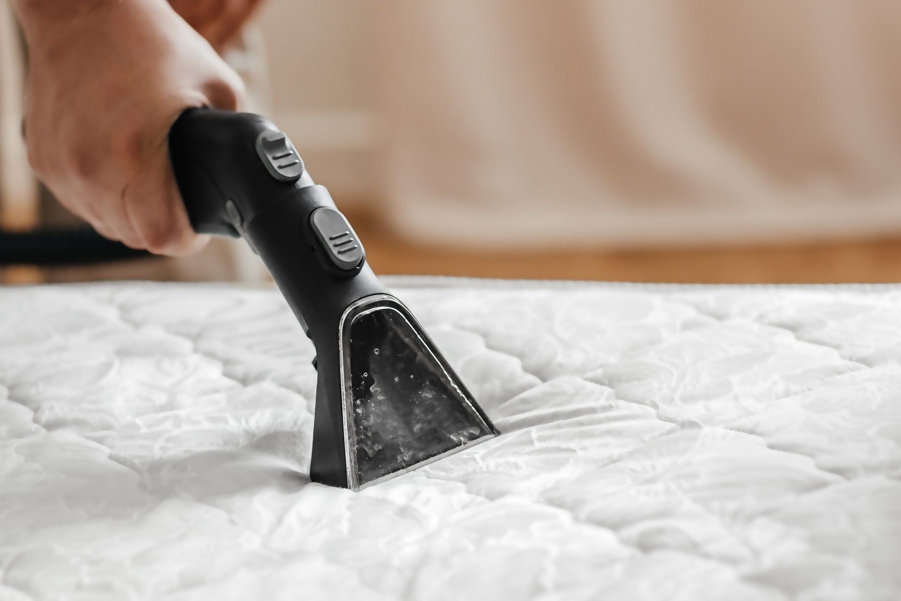 Topper wird vom Boxspringbett abgenommen und abgesaugt